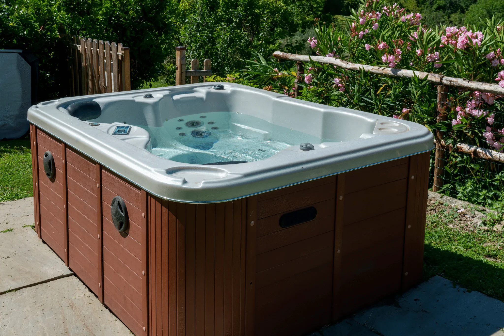 An outdoor hot tub privacy enclosure created with fences and landscaping.